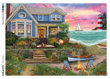 This 1000 piece puzzle features a David Maclean painting of a blue house on the beach, with a lighthouse and a sailboat under a picturesque sunset in the background. A dog is reclining on the front porch and another plays in the front yard, near a pair of deck chairs and a fire pit.